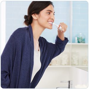 Frau putzt sich die Zähne im Bad